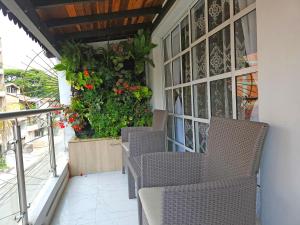 a patio with chairs and flowers on a balcony at Casa de Huéspedes Colibrí in Envigado