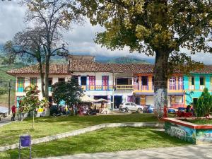 a colorful building with a tree in front of it at Alojamiento Rural Cafetero, Andinapolis, Trujillo 