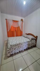 una camera da letto con un letto con una tenda e una finestra di Sitio Balneario do Sossego a Rolante