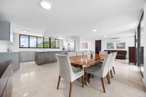 a kitchen and dining room with a wooden table and chairs at Intimate Paradise-Pool, Terrace & Private Bedrooms in San Juan