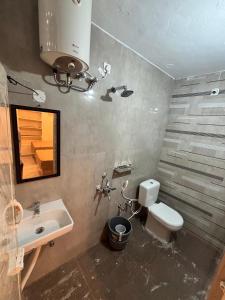 une salle de bain avec un lavabo, des toilettes et un miroir dans l'établissement Snekam Inn, à Tiruvannāmalai 22 autres photos