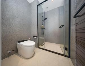 a bathroom with a toilet and a glass shower at Leaf Hotel in Yantaiqian +6 photos