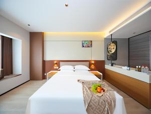 a bedroom with a large white bed and a sink at Leaf Hotel in Yantaiqian