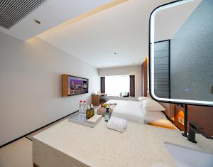 a living room with a large flat screen tv at Leaf Hotel in Yantaiqian