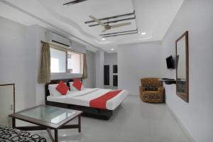 a bedroom with a bed and a table and a couch at Hotel O Rudra Palace in Ahmedabad +19 photos