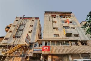 two tall buildings are under construction on a street at Hotel O Rudra Palace in Ahmedabad