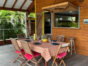 a wooden table with chairs and a tableasteryasteryasteryasteryasteryasteryasteryastery at Villa Atypique - Charme & Confort in Le Moule