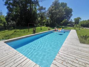 a swimming pool in a yard with a wooden deck at Domaine Ecoline in Sadirac