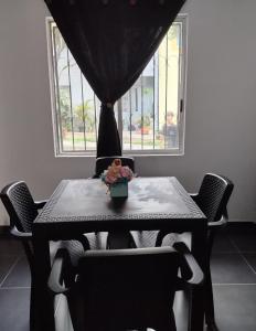 a black table with chairs and a vase on it at Casa azul en Piedecuesta in Piedecuesta