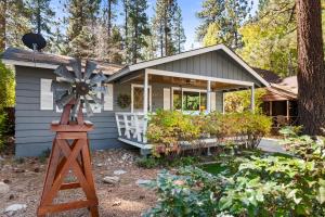 una pequeña casa con un molino de viento delante en Tranquil Retreat with Fenced Backyard, Hot tub & Bar, en Big Bear City