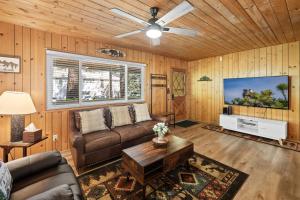 Una sala de estar con un sofá y un televisor de pantalla plana. en Tranquil Retreat with Fenced Backyard, Hot tub & Bar, en Big Bear City