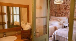 un bagno con un lavandino, un letto e uno specchio di Casa Josefina Hotel Boutique a Olavarría