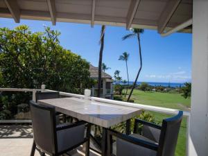 a table and chairs on a patio with a view of the ocean at Wailea Grand Champions 84 in Wailea