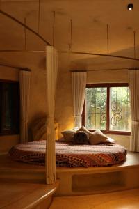a bedroom with a canopy bed with windows at Amaya Retreat in Sóc Sơn