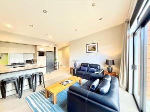 ein Wohnzimmer mit Sofa und Tisch in der Unterkunft @MyHolidays - My Remarkable view in Queenstown