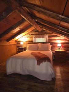 a bedroom with a white bed in an attic at Charming Country Cabin- Cozy, Scenic View, HOT TUB in Rushville