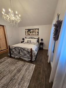 a bedroom with a bed and a chandelier at Charming Country Cabin- Cozy, Scenic View, HOT TUB in Rushville +34 photos