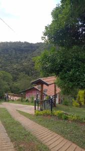 a building with a shelter next to a road at Sonho na Serra Chalé 1 in Gonçalves +36 photos