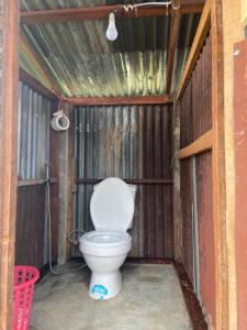 a bathroom with a toilet in a wooden structure at OrganicHomeFarmStay in Ban Na Sông