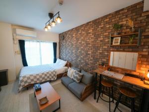 une chambre avec un lit et un mur de briques dans l'établissement REVISION Kairouyama-tei - Vacation STAY 15801, à Hiroshima