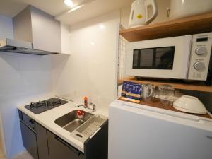 a small kitchen with a sink and a microwave at REVISION Kairouyama-tei - Vacation STAY 15802 in Hiroshima