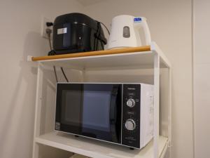 a microwave oven on a shelf with a blender at REVISION Ebiyama-tei - Vacation STAY 15809 in Hiroshima +2 photos