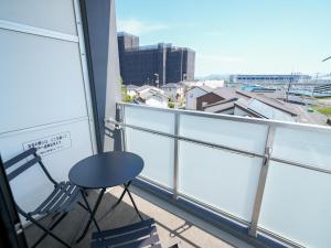 a chair on a balcony with a view of a city at REVISION Ebiyama-tei - Vacation STAY 15811 in Hiroshima