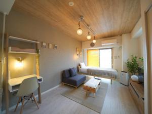 広島市にあるREVISION Ebiyama-tei - Vacation STAY 16834のベッド、デスク、二段ベッドが備わる小さな客室です。