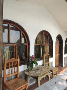 a room with a table and two chairs and windows at ELOA Atitlán in San Marcos La Laguna
