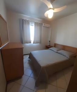 une chambre avec un lit et une fenêtre dans l'établissement Apartamento com VISTA para o MAR no centro de Bombinhas, à Bombinhas