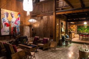 a living room with wooden walls and a couch and chairs at De Yang House Sa Pa in Sapa