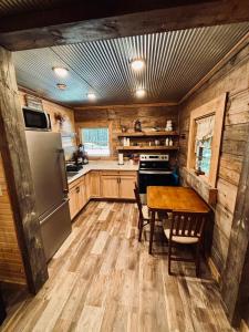 une cuisine avec une table et un réfrigérateur dans l'établissement The Rustic Ave Red River Gorge, 