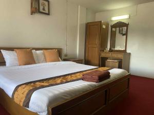 a bedroom with a large bed with a mirror at โรงแรมเชียงดาวอินน์ Chiangdaoinnhotel in Chiang Dao
