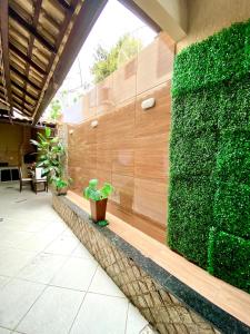 eine grüne Wand mit Pflanzen an der Seite eines Gebäudes in der Unterkunft Casa Aconchegante no Coração de Arraial - Com Churrasqueira Privativa in Arraial do Cabo