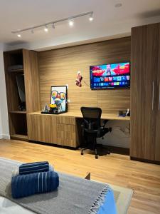 an office with a desk with a monitor and a chair at Apartamento Giardino Maia, Café da Manhã cortesia em dias úteis in Guarulhos +24 photos
