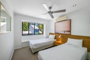 two beds in a room with two windows at Ivory Palms Resort Noosa in Noosaville