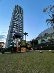 une aire de jeux en face d'un grand bâtiment dans l'établissement Giardino, Studio Moderno Aconchegante e Tranquilo, à Guarulhos