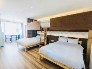 a bedroom with two bunk beds and a chair at THE LOBS, RUSUTSU in Kimobetsu