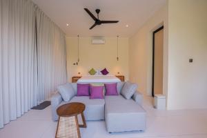 a living room with a couch and a bed at Villa Dua Sungai in Sempidi
