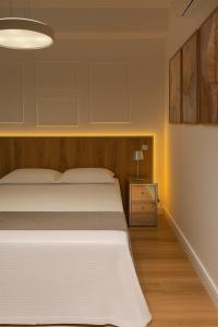 une chambre avec un lit blanc et un parquet dans l'établissement Giardino, Studio Moderno Aconchegante e Tranquilo, à Guarulhos