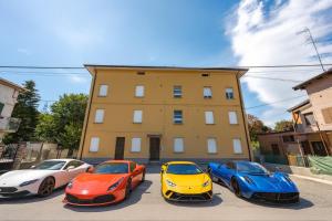 a group of four cars parked in front of a building at Rubiera Residence - H24 in Zimella