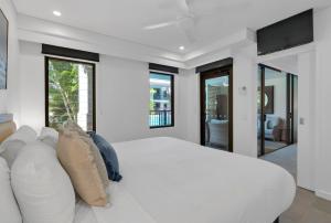 una camera da letto bianca con un letto grande e un divano di Lagoon Sanctuary - Resort Living by Four Mile Beach a Craiglie