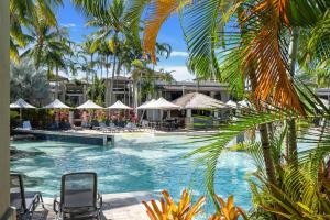 una piscina in un resort con sedie e ombrelloni di Lagoon Sanctuary - Resort Living by Four Mile Beach a Craiglie