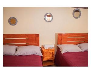 two beds in a bedroom with two mirrors on the wall at Casa Jhada-Xilitla in Xilitla