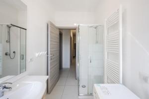 a white bathroom with a shower and a sink at RUBIERA Residence House  +42 photos