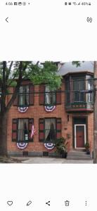 a red brick building with a flag banner on it at Langdon Hill House Felty Room in Gettysburg