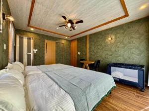 een slaapkamer met een bed en een plafondventilator bij ヴィラ マイラニハウス沖縄 in Hamakawa