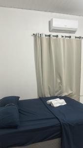 a bedroom with a blue bed with a curtain at Primeiro andar charmoso in Maragogi