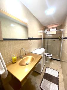 ein Badezimmer mit Waschbecken und Toilette in der Unterkunft Casa Aconchegante no Coração de Arraial - Com Churrasqueira Privativa in Arraial do Cabo