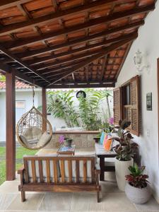 a patio with a bench and a swing at Pousada Romã in Paraty